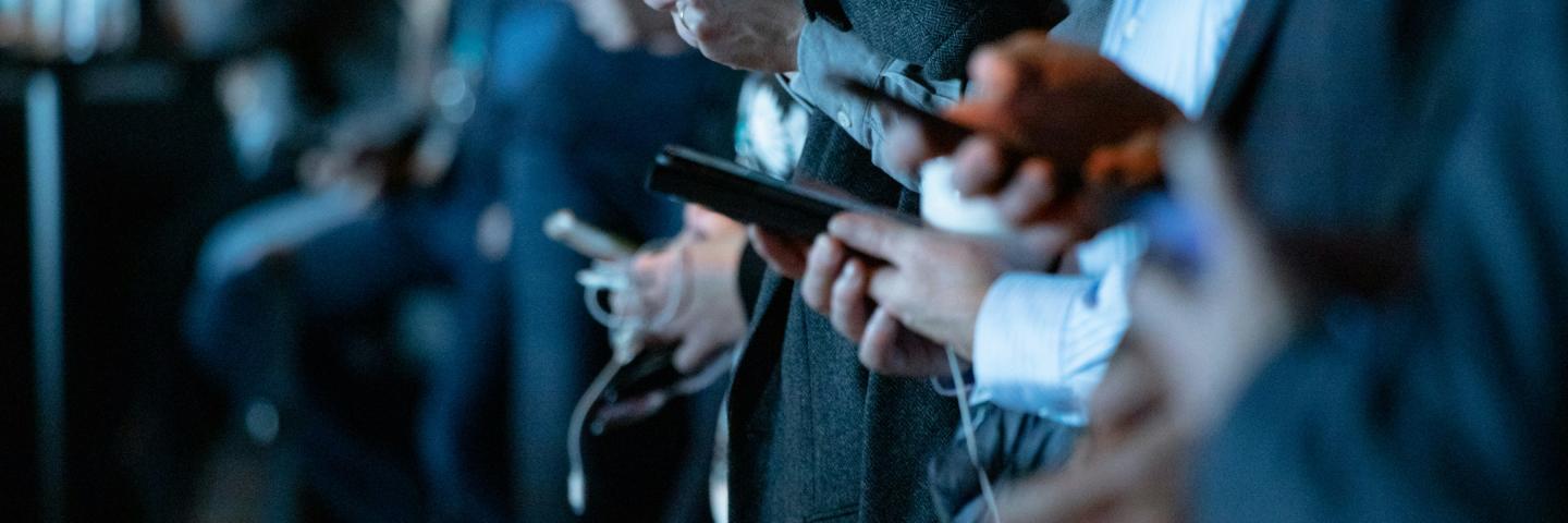 Menschen in einer Reihe mit Smartphone in der Hand