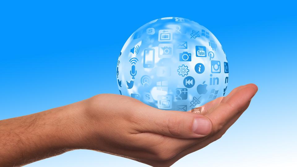 Weltkugel mit Social Media Icons auf einer ausgestreckten Hand